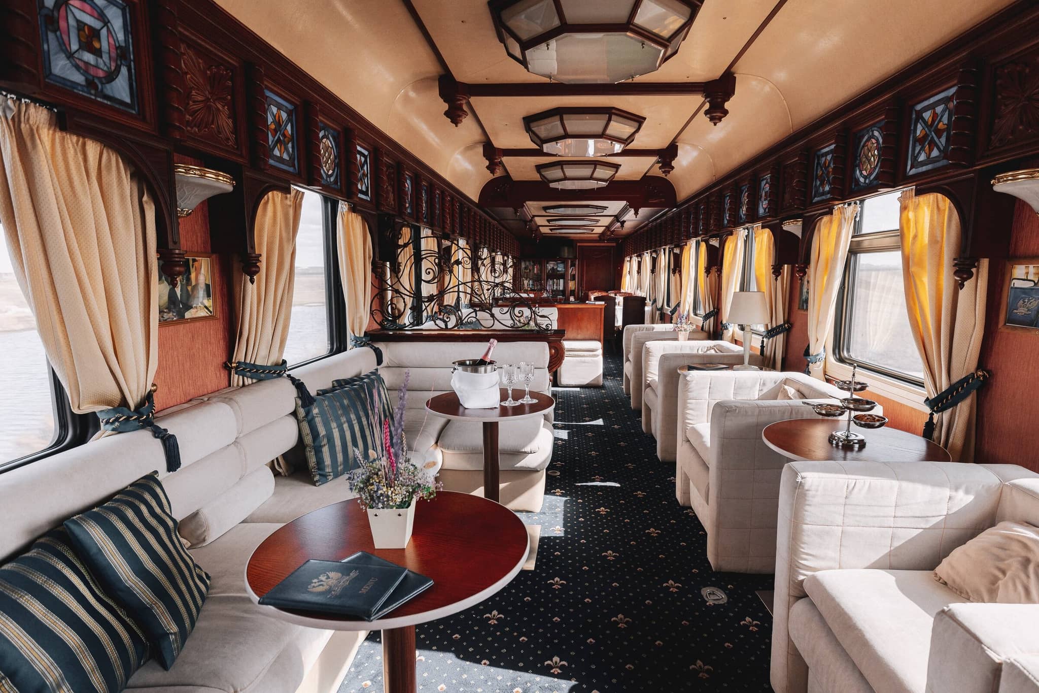 Elegant lounge interior with champagne on a luxury train travel experience.