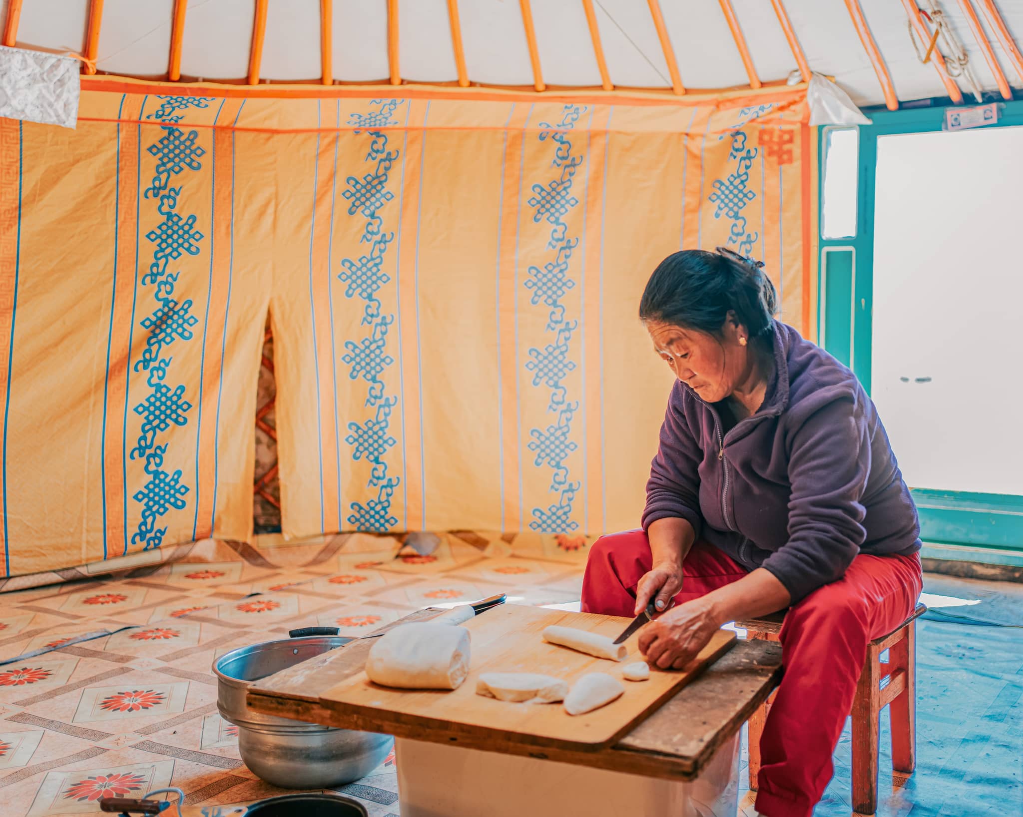 Mongolian woman making Buuz, traditional food dumpling in yurt
