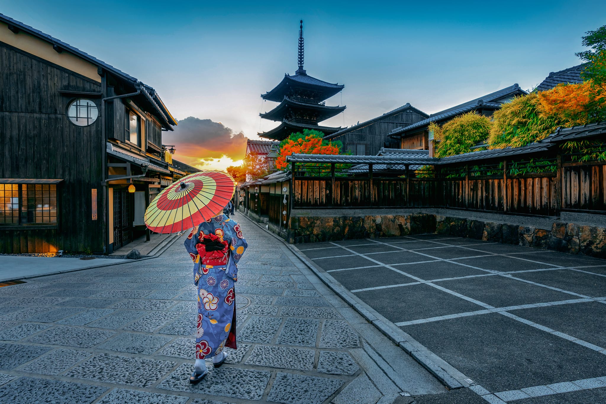Kyoto’s serene temple pathway lined with traditional architecture & blooming cherry blossoms